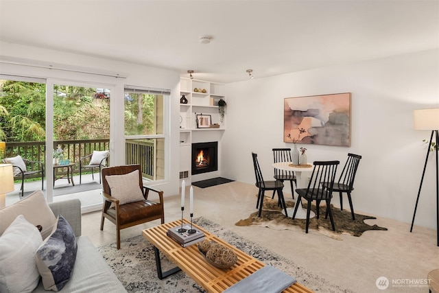 living room with light carpet and a fireplace with flush hearth