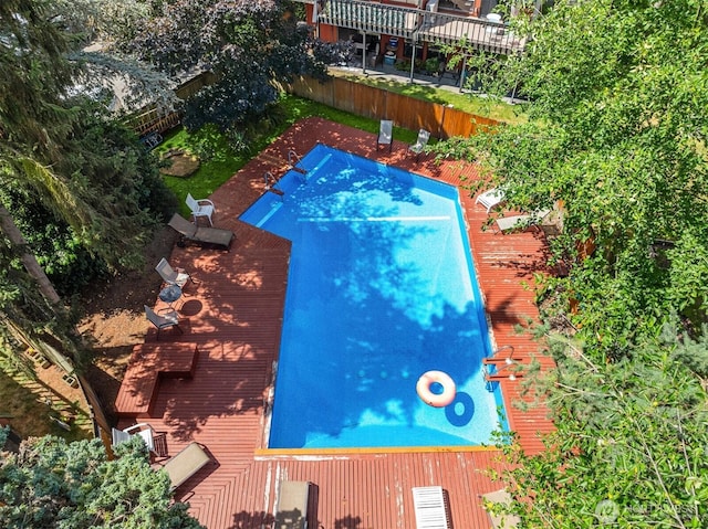 view of swimming pool featuring fence and a wooden deck