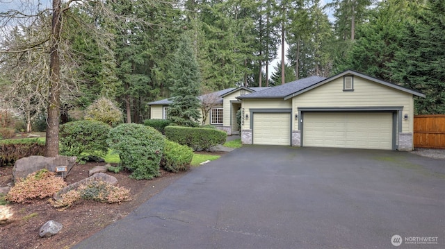 single story home with aphalt driveway, an attached garage, and brick siding