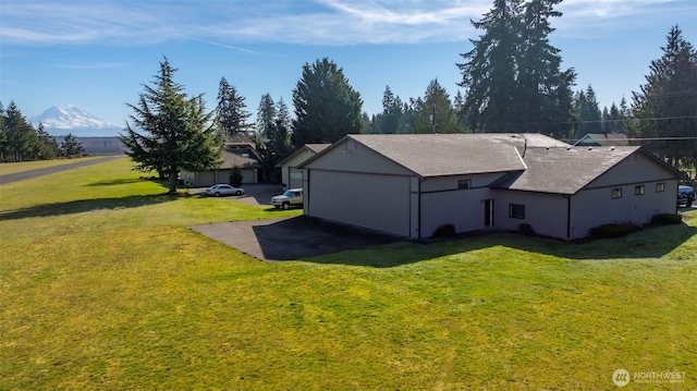 view of property exterior with a mountain view and a yard