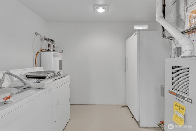 washroom with laundry area, washing machine and dryer, and electric water heater