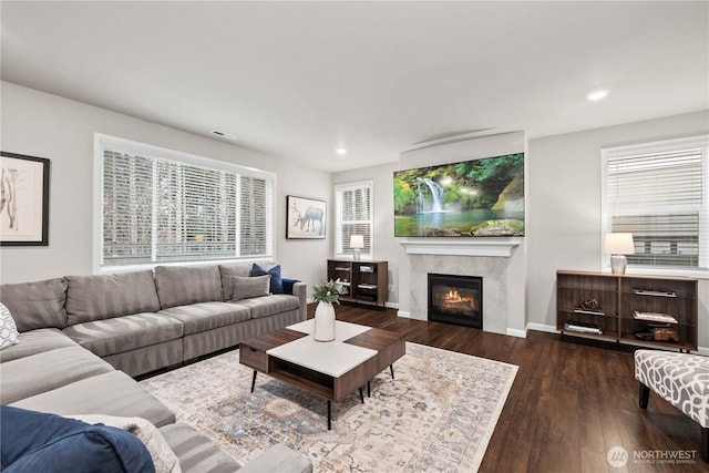 living area featuring dark wood-style flooring, recessed lighting, a tile fireplace, plenty of natural light, and baseboards