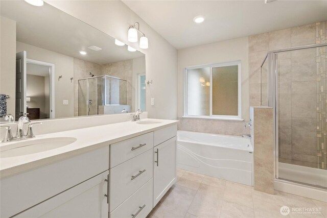 bathroom featuring tile patterned flooring, a sink, a bath, and double vanity