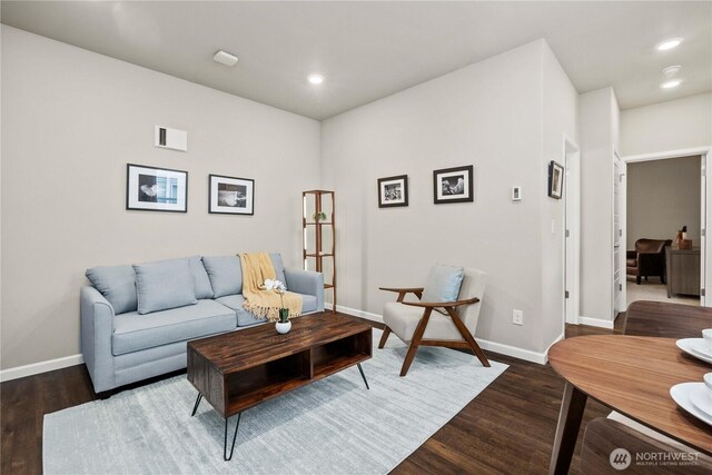 living room with dark wood-style floors, visible vents, and baseboards