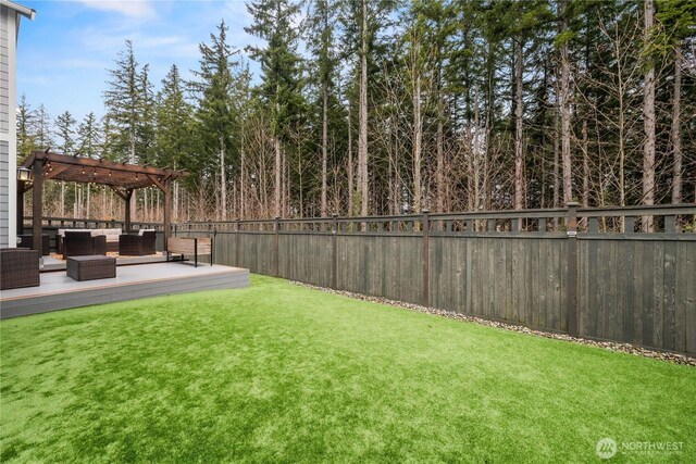 view of yard with outdoor lounge area, a fenced backyard, a wooden deck, and a pergola