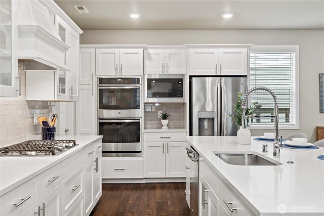 kitchen featuring stainless steel appliances, light countertops, and glass insert cabinets