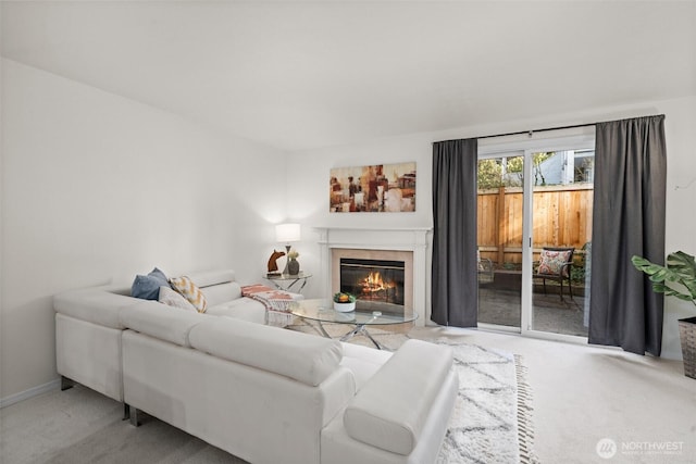 living room with a glass covered fireplace and light carpet