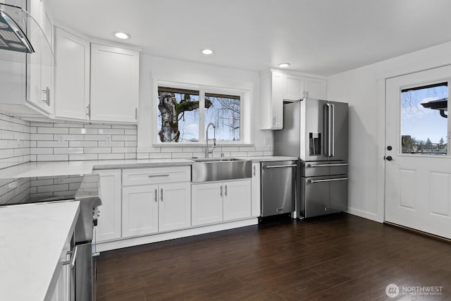 kitchen featuring appliances with stainless steel finishes, a wealth of natural light, white cabinets, and a sink