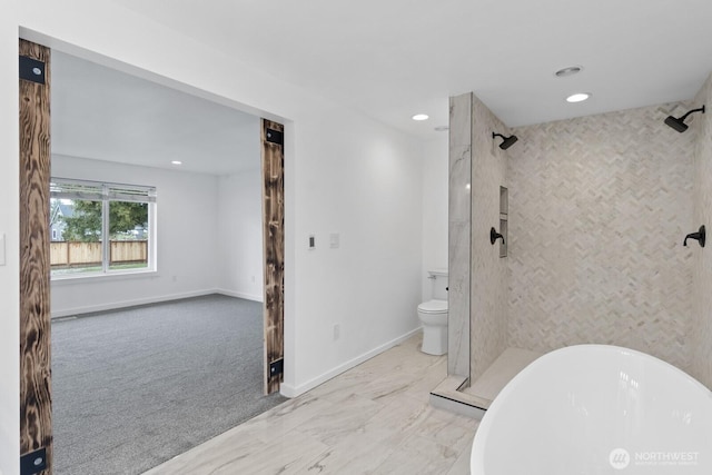 bathroom featuring recessed lighting, toilet, a stall shower, a freestanding tub, and baseboards