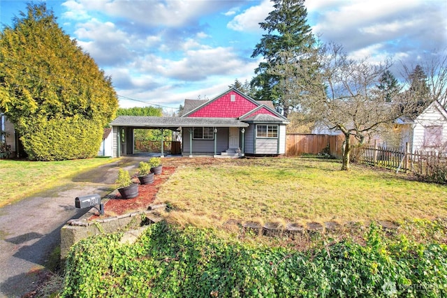 view of front of house with driveway, a front lawn, fence, and an attached carport