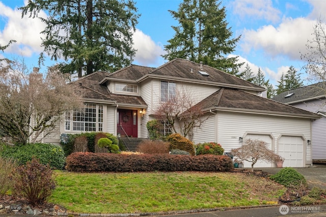 traditional home featuring aphalt driveway, an attached garage, and a front yard