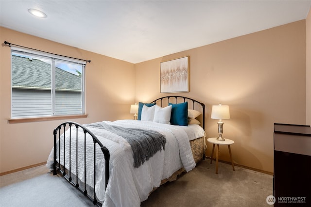 bedroom with light colored carpet and baseboards