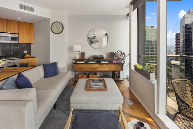 500 106th Ave NE Unit 2309, Bellevue, WA 98004 - living area featuring a view of city, wood finished floors, visible vents, and baseboards