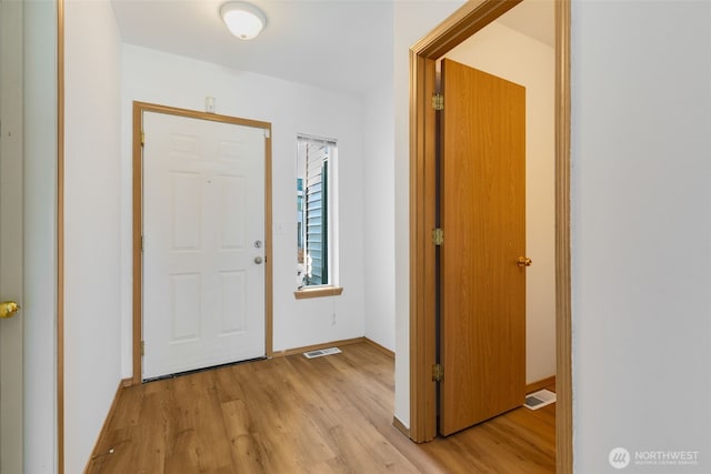 entryway featuring light wood finished floors, visible vents, and baseboards