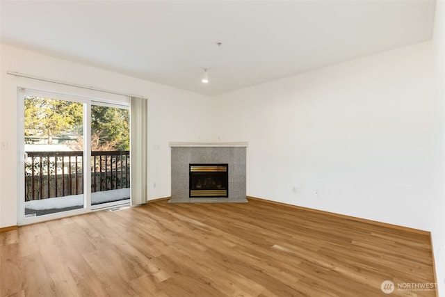 unfurnished living room with light wood finished floors and a premium fireplace