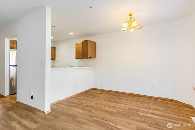 unfurnished living room with light wood-style flooring, a chandelier, and recessed lighting