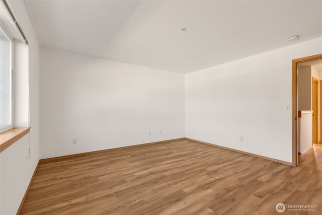 spare room with light wood-style floors and plenty of natural light