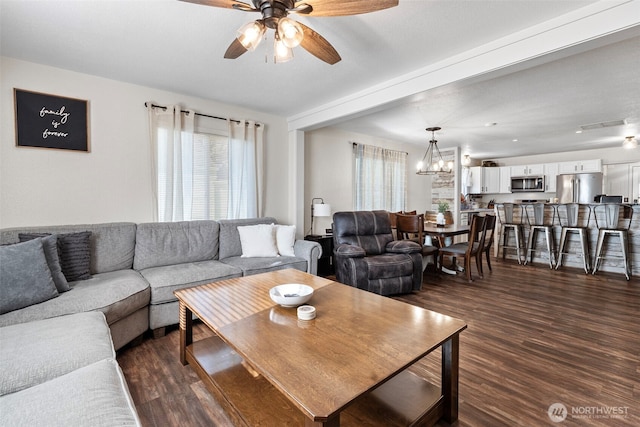 living room featuring dark wood-style floors and ceiling fan with notable chandelier