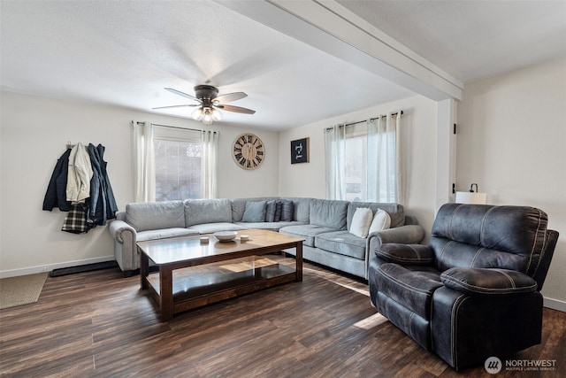 living area featuring baseboards, dark wood-style flooring, and a healthy amount of sunlight