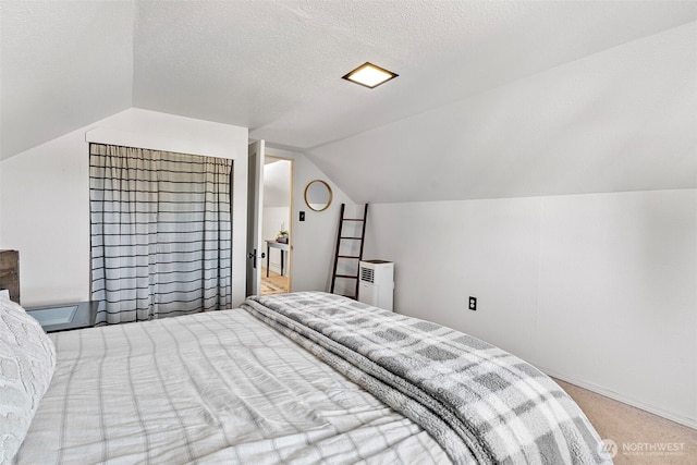 bedroom with light colored carpet, vaulted ceiling, a textured ceiling, and baseboards