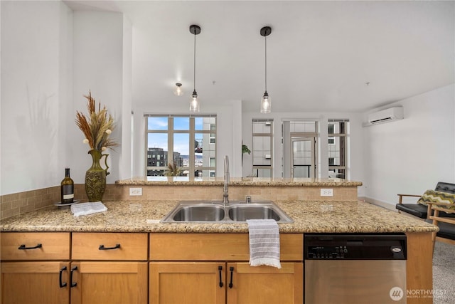 kitchen with dishwasher, a wall unit AC, hanging light fixtures, light stone countertops, and a sink