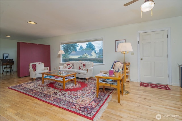 living area with ceiling fan and light wood-type flooring