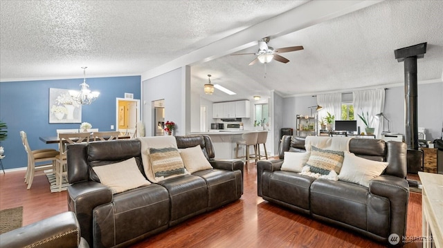 living area with lofted ceiling, dark wood-type flooring, crown molding, a textured ceiling, and ceiling fan with notable chandelier