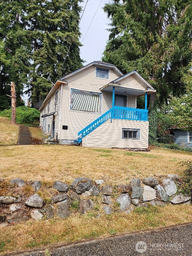 view of front of property featuring a balcony and a front lawn