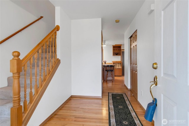 foyer with light wood finished floors and baseboards