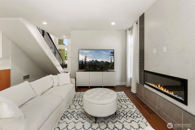 living room with a fireplace, stairway, dark wood-type flooring, and recessed lighting