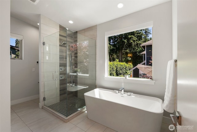 full bathroom featuring a stall shower, a soaking tub, a healthy amount of sunlight, and tile patterned floors