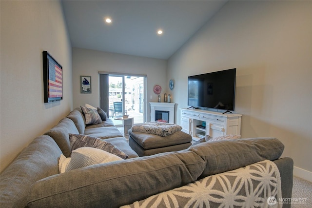 carpeted living area with baseboards, high vaulted ceiling, a fireplace, and recessed lighting