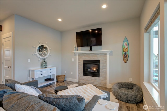 living area with baseboards, a tile fireplace, wood finished floors, and recessed lighting