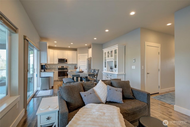 living room with baseboards, wood finished floors, and recessed lighting