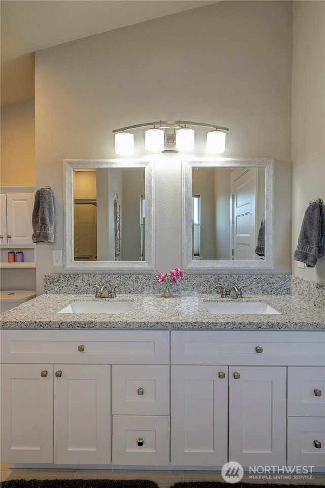 full bath with a sink and double vanity