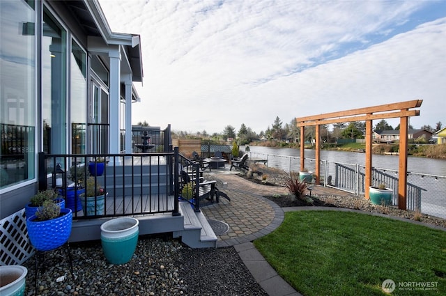 view of patio featuring a water view and fence