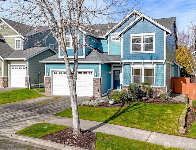 craftsman-style home featuring a garage, fence, stone siding, driveway, and roof with shingles