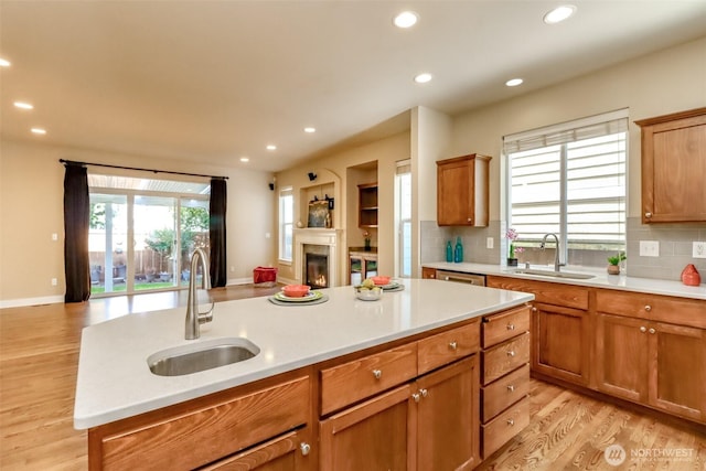 kitchen featuring open floor plan, light countertops, and a sink