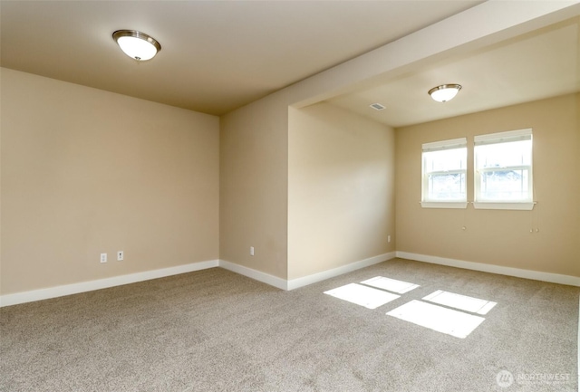 spare room with visible vents, baseboards, and light colored carpet