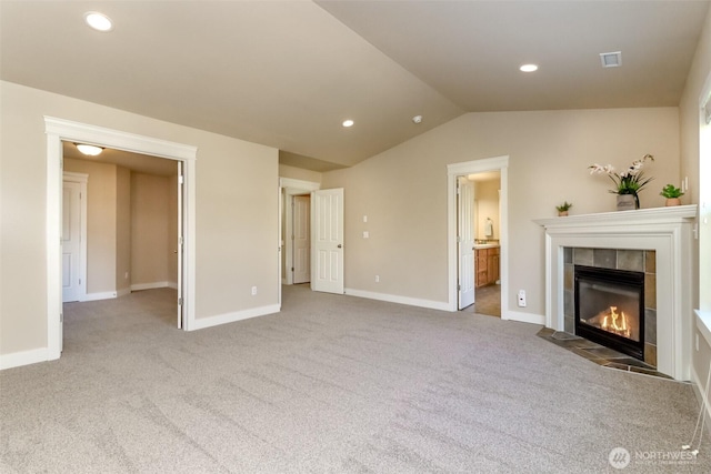 unfurnished living room featuring recessed lighting, visible vents, vaulted ceiling, a tile fireplace, and baseboards