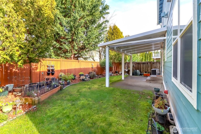 view of yard with a patio, fence, a vegetable garden, and central air condition unit