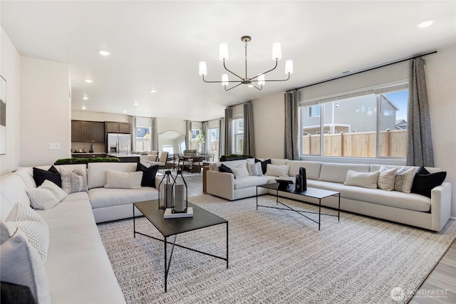 living room with light hardwood / wood-style flooring and a notable chandelier