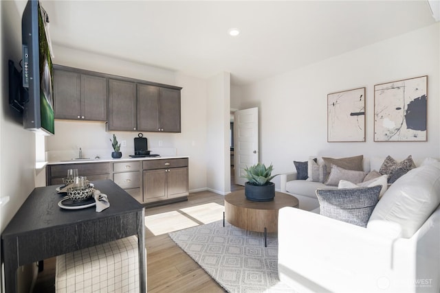 living room with sink and light hardwood / wood-style flooring