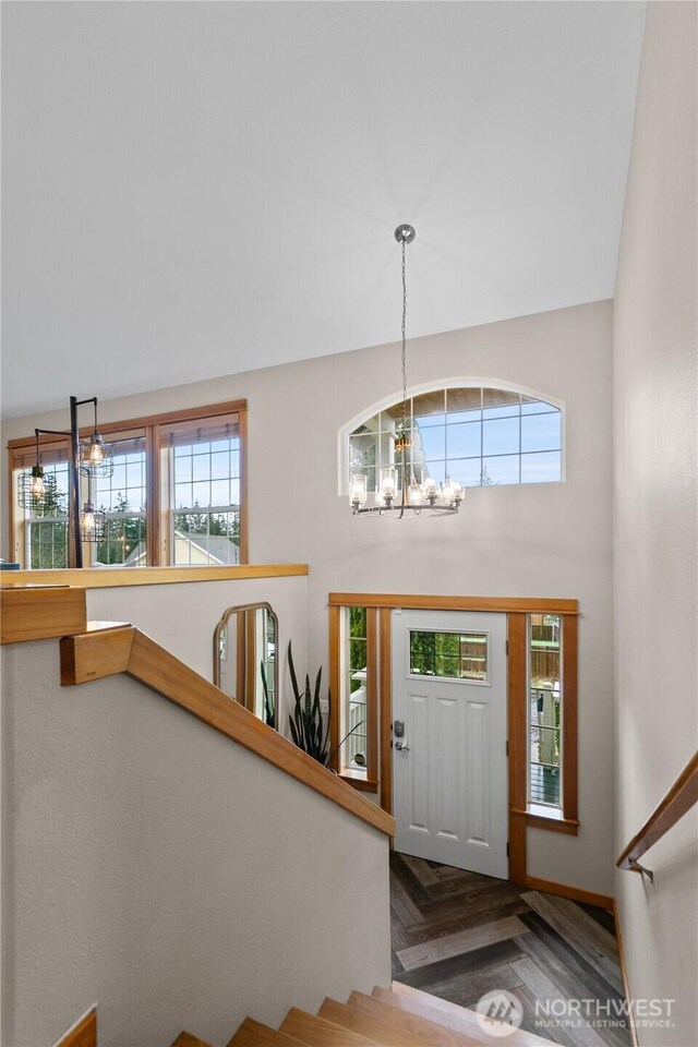 foyer featuring stairway, a wealth of natural light, and a notable chandelier