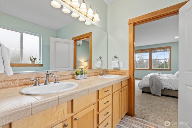 ensuite bathroom with a sink, double vanity, and connected bathroom