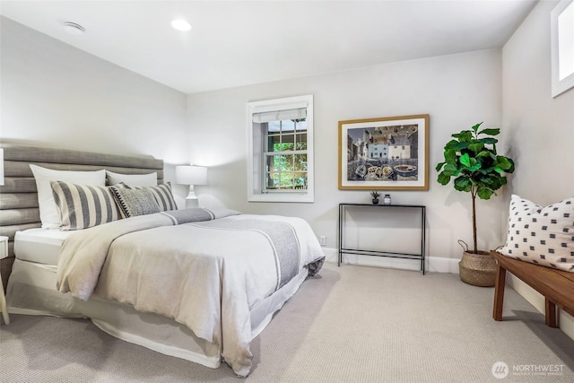 bedroom featuring light carpet and baseboards