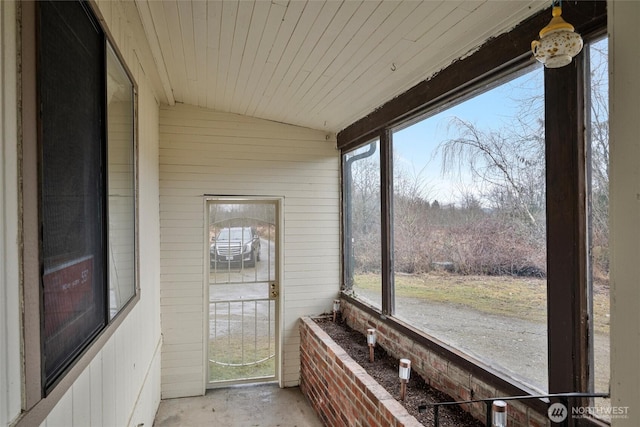 unfurnished sunroom with wooden ceiling, vaulted ceiling, and a wealth of natural light