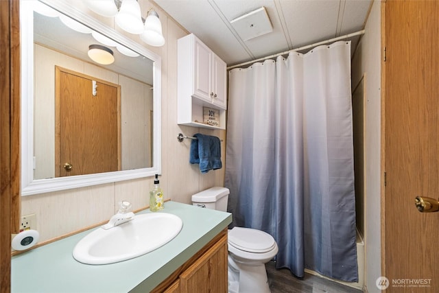 full bath with wood finished floors, vanity, toilet, and shower / bathtub combination with curtain