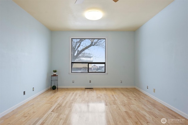 unfurnished room featuring baseboards and wood finished floors