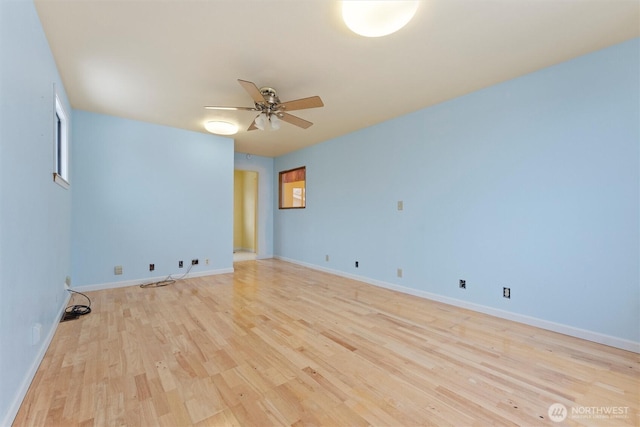 spare room featuring baseboards, light wood-style flooring, and a ceiling fan